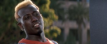 Movie still from “Demolition Man” (1993), directed by Marco Brambilla – A man smiling for the camera; Close Up shot, Low angle