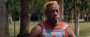 Movie still from “Demolition Man” (1993), directed by Marco Brambilla – A person with a yellow mohawk hair style; Close Up shot, High angle