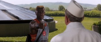 Movie still from “Demolition Man” (1993), directed by Marco Brambilla – An african american man holding a video game controller; Medium shot, Over the shoulder angle