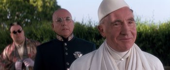 Movie still from “Demolition Man” (1993), directed by Marco Brambilla – A man in a suit and a man in a white hat; Close Up shot, Low angle