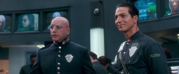 Movie still from “Demolition Man” (1993), directed by Marco Brambilla – A man in a uniform next to another man in a uniform; Close Up shot, Over the shoulder angle