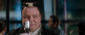 Movie still from “Demolition Man” (1993), directed by Marco Brambilla – A person holding a glass of wine; Close Up shot, Over the shoulder angle