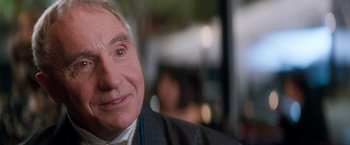 Movie still from “Demolition Man” (1993), directed by Marco Brambilla – An older man is smiling for the camera; Close Up shot, Over the shoulder angle