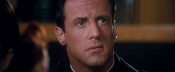 Movie still from “Demolition Man” (1993), directed by Marco Brambilla – A person wearing a black shirt; Close Up shot, High angle