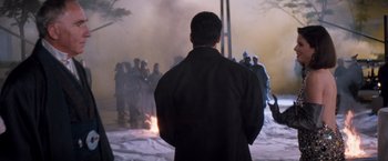 Movie still from “Demolition Man” (1993), directed by Marco Brambilla – A man standing in front of a group of people; Wide shot, Over the shoulder angle