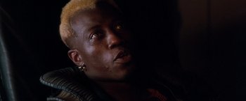 Movie still from “Demolition Man” (1993), directed by Marco Brambilla – A person with yellow hair; Close Up shot, Low angle