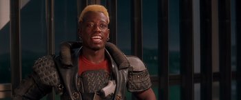 Movie still from “Demolition Man” (1993), directed by Marco Brambilla – A man with yellow hair is smiling for the camera; Close Up shot, High angle