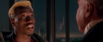 Movie still from “Demolition Man” (1993), directed by Marco Brambilla – A person holding a microphone; Close Up shot, Over the shoulder angle