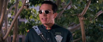 Movie still from “Demolition Man” (1993), directed by Marco Brambilla – A man wearing sunglasses and holding a cell phone; Close Up shot, Low angle