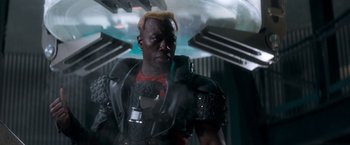 Movie still from “Demolition Man” (1993), directed by Marco Brambilla – A man in a black leather jacket standing next to a building; Close Up shot, Low angle