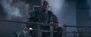 Movie still from “Demolition Man” (1993), directed by Marco Brambilla – A man with a helmet on sitting in a chair; Close Up shot, High angle