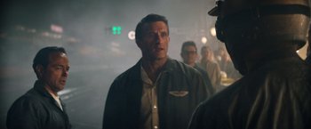 Movie still from “Ford v Ferrari” (2019), directed by James Mangold – A group of people standing in a foggy area; Medium shot, Over the shoulder angle