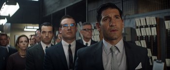 Movie still from “Ford v Ferrari” (2019), directed by James Mangold – A group of men standing next to each other in suits; Medium shot, Low angle