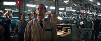 Movie still from “Ford v Ferrari” (2019), directed by James Mangold – A group of men standing in a room; Medium shot, Low angle