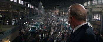Movie still from “Ford v Ferrari” (2019), directed by James Mangold – A crowd of people standing around a building with cars; Extreme Wide shot, High angle