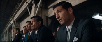Movie still from “Ford v Ferrari” (2019), directed by James Mangold – A man in a suit and tie sitting next to another man in a suit and tie; Close Up shot, Low angle