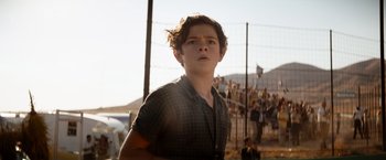 Movie still from “Ford v Ferrari” (2019), directed by James Mangold – A young man standing in front of a fence; Medium shot, Low angle