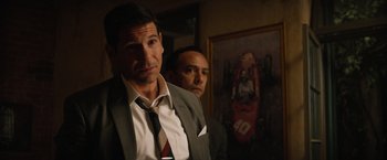 Movie still from “Ford v Ferrari” (2019), directed by James Mangold – A man in a suit standing next to another man in a suit; Close Up shot, Over the shoulder angle