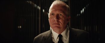 Movie still from “Ford v Ferrari” (2019), directed by James Mangold – An older man wearing a suit and tie; Close Up shot, Low angle