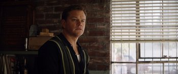 Movie still from “Ford v Ferrari” (2019), directed by James Mangold – A man standing in front of a brick wall; Close Up shot, Over the shoulder angle