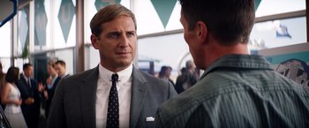 Movie still from “Ford v Ferrari” (2019), directed by James Mangold – A man in a suit and tie talking to another man in a suit and tie; Close Up shot, Over the shoulder angle