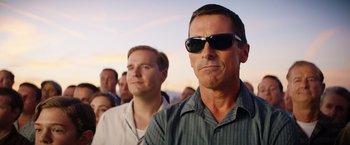 Movie still from “Ford v Ferrari” (2019), directed by James Mangold – A man with sunglasses is standing in front of a crowd; Close Up shot, Low angle
