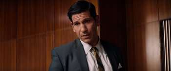 Movie still from “Ford v Ferrari” (2019), directed by James Mangold – A person wearing a suit and tie; Close Up shot, Over the shoulder angle