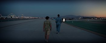 Movie still from “Ford v Ferrari” (2019), directed by James Mangold – Two men are walking down a runway at night; Wide shot, Over the shoulder angle