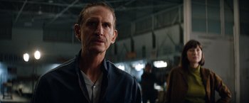 Movie still from “Ford v Ferrari” (2019), directed by James Mangold – A person wearing a blue shirt; Close Up shot, Over the shoulder angle