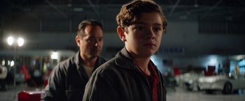 Movie still from “Ford v Ferrari” (2019), directed by James Mangold – A man and a young boy standing next to each other; Close Up shot, Over the shoulder angle