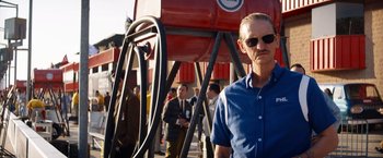 Movie still from “Ford v Ferrari” (2019), directed by James Mangold – A group of men standing next to each other near a fire hydrant; Medium shot, Low angle
