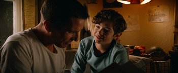 Movie still from “Ford v Ferrari” (2019), directed by James Mangold – A man and a boy are looking at each other; Close Up shot, Over the shoulder angle