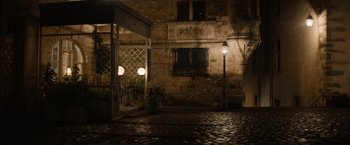 Movie still from “Ford v Ferrari” (2019), directed by James Mangold – An outdoor cafe with a lamp post and a building; Extreme Wide shot, High angle