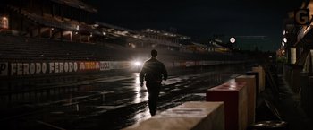 Movie still from “Ford v Ferrari” (2019), directed by James Mangold – A man walking in the rain at a race track at night; Extreme Wide shot, Low angle