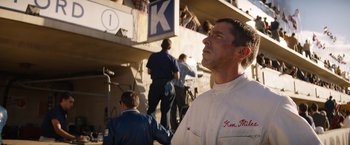 Movie still from “Ford v Ferrari” (2019), directed by James Mangold – A man standing in front of a group of people; Medium shot, Low angle