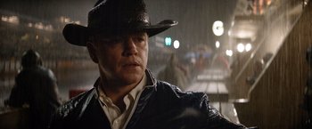 Movie still from “Ford v Ferrari” (2019), directed by James Mangold – A man wearing a cowboy hat in the pouring rain; Close Up shot, Low angle