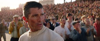 Movie still from “Ford v Ferrari” (2019), directed by James Mangold – A crowd of people in a stadium watching a game; Close Up shot, Over the shoulder angle