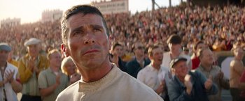 Movie still from “Ford v Ferrari” (2019), directed by James Mangold – A crowd of people standing in front of an audience; Close Up shot, Low angle