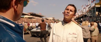 Movie still from “Ford v Ferrari” (2019), directed by James Mangold – A man standing in front of a group of people; Close Up shot, Low angle