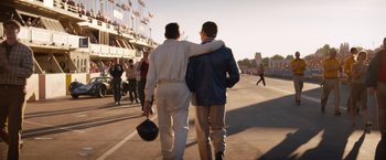 Movie still from “Ford v Ferrari” (2019), directed by James Mangold – A couple of men walking down a street together; Wide shot, Over the shoulder angle