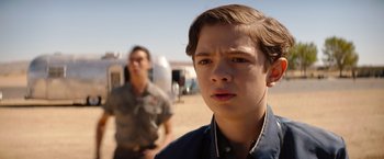 Movie still from “Ford v Ferrari” (2019), directed by James Mangold – A young boy standing in front of another man; Close Up shot, Over the shoulder angle