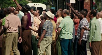 Movie still from “Detroit” (2017), directed by Kathryn Bigelow – A group of men standing next to each other on a street; Wide shot, Low angle
