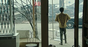 Movie still from “Detroit” (2017), directed by Kathryn Bigelow – A man standing in front of an open window; Wide shot, Over the shoulder angle