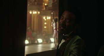 Movie still from “Detroit” (2017), directed by Kathryn Bigelow – A man in a green jacket and a bow tie; Medium shot, Over the shoulder angle
