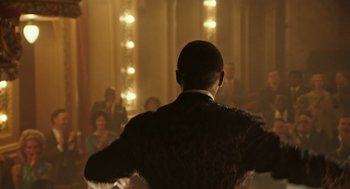 Movie still from “Detroit” (2017), directed by Kathryn Bigelow – A man is standing in front of a group of people; Medium shot, Over the shoulder angle