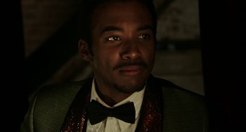 Movie still from “Detroit” (2017), directed by Kathryn Bigelow – A person wearing a suit and bow tie; Close Up shot, Low angle