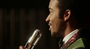 Movie still from “Detroit” (2017), directed by Kathryn Bigelow – A person holding a microphone; Extreme Close Up shot, Over the shoulder angle
