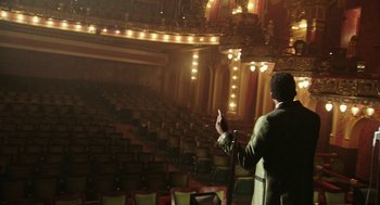 Movie still from “Detroit” (2017), directed by Kathryn Bigelow – A man is standing in front of an empty theater; Wide shot, High angle