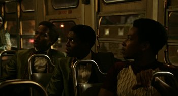 Movie still from “Detroit” (2017), directed by Kathryn Bigelow – A group of men riding on a bus together at night; Medium shot, Over the shoulder angle