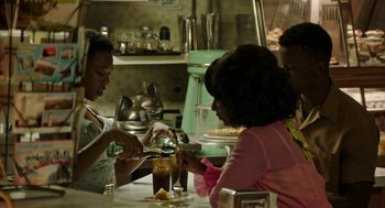 Movie still from “Detroit” (2017), directed by Kathryn Bigelow – Two women and a man sitting at a table in a restaurant; Medium shot, Over the shoulder angle